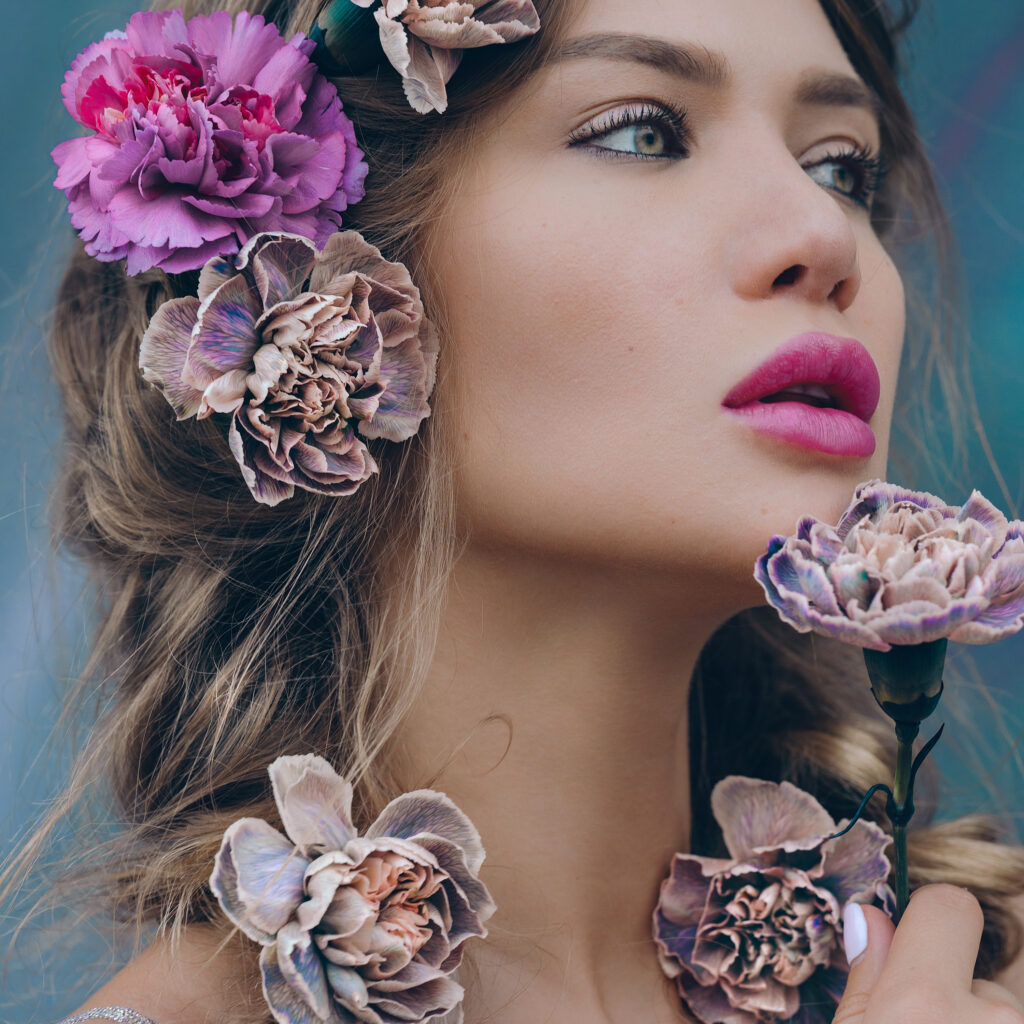 En perfekt midsommar-look med en naturlig sminkbas, färgstarka läppar, flätor och blommor i håret.